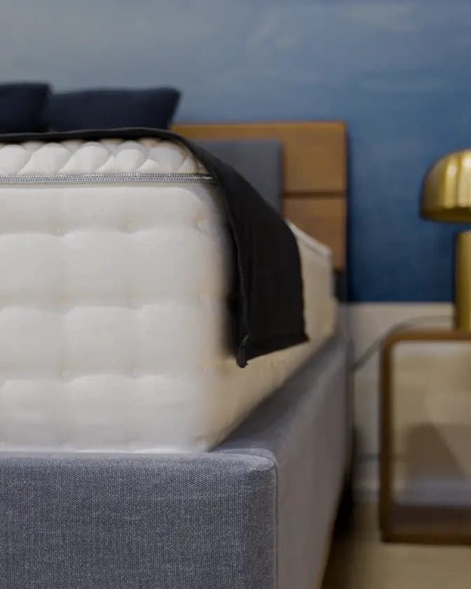 Gestepptes Boxspringbett mit dunkler Decke und Messingleuchte